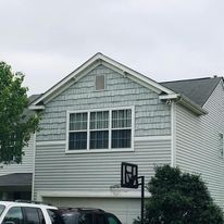 A white house with a basketball hoop in front of it.