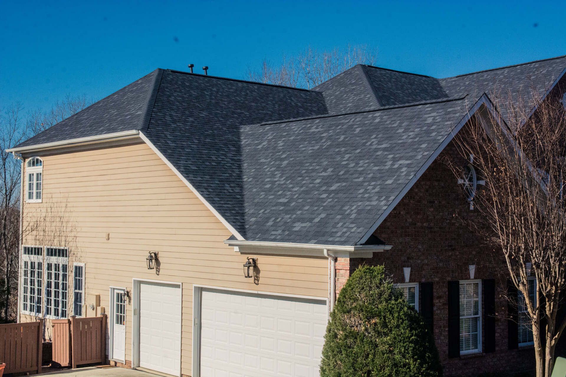 A large house with a black roof and a white garage door.