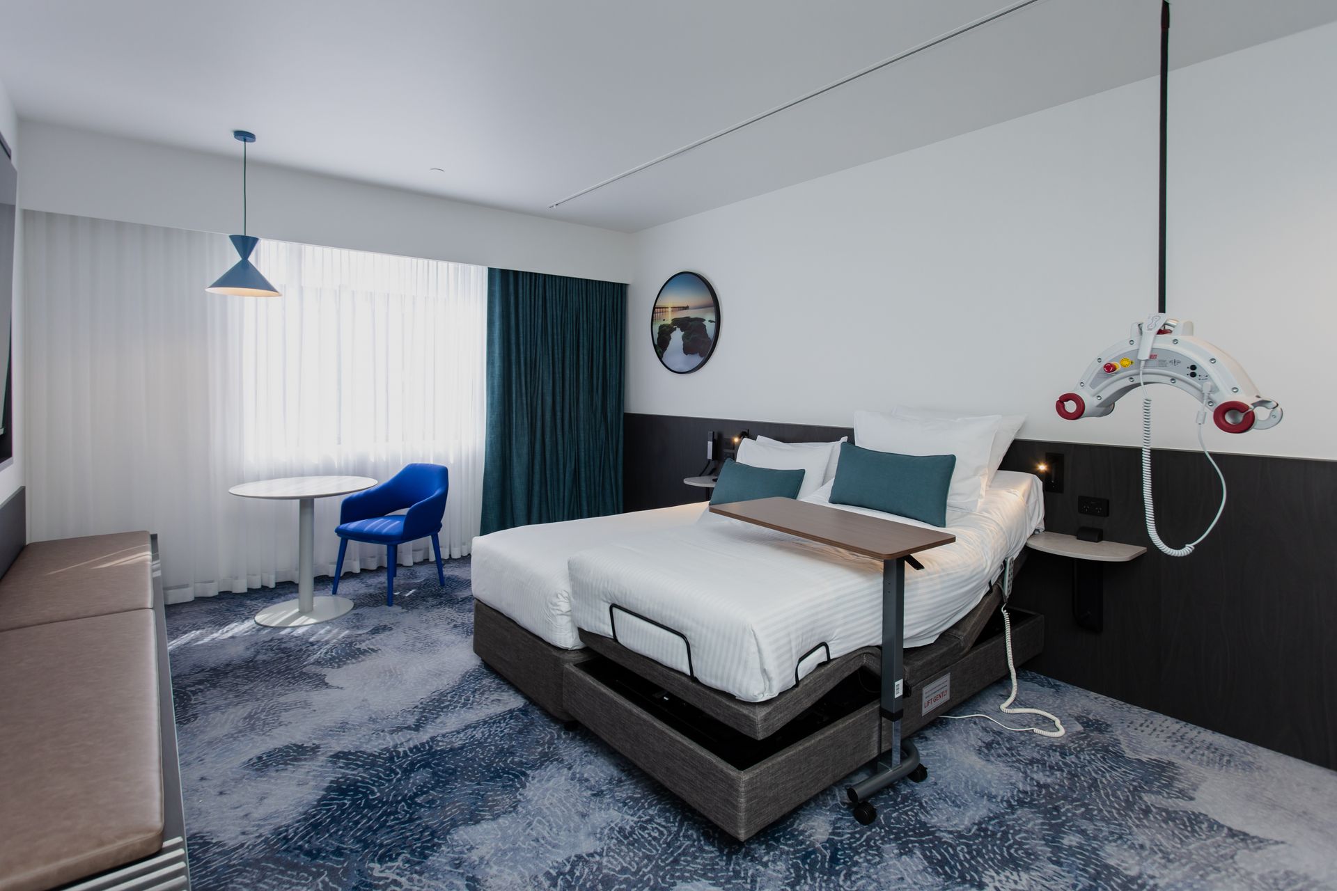 Hotel room with adjustable bed, lift system, and accessible features.