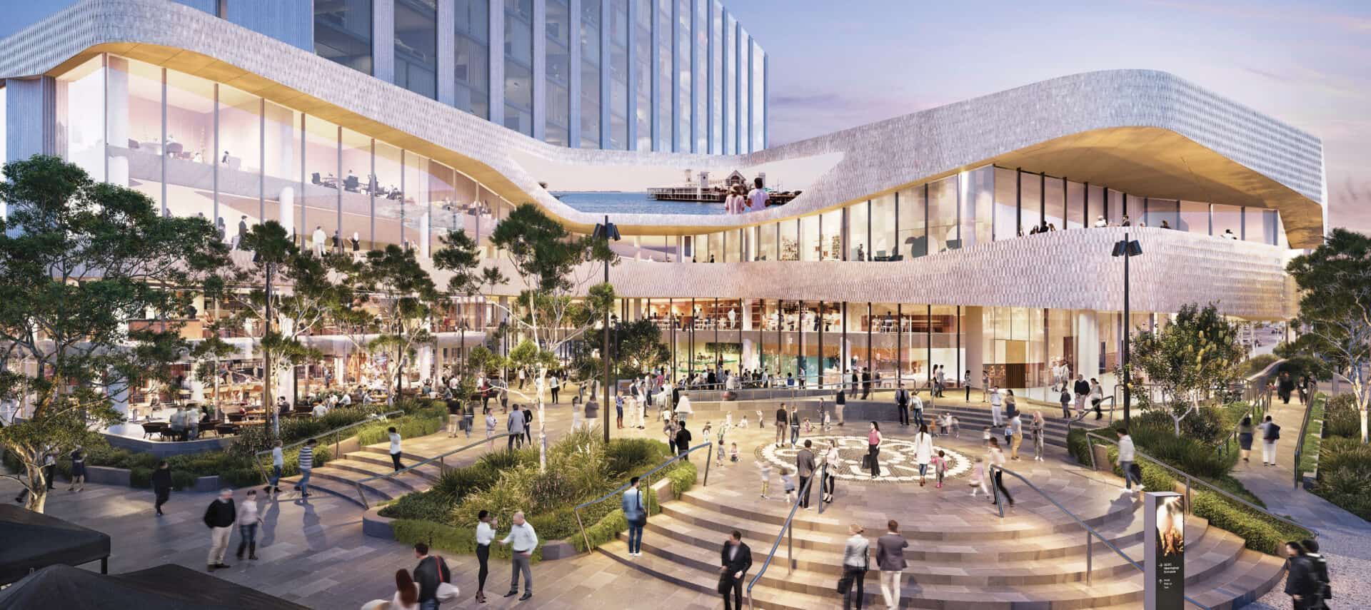 Modern building complex with people in an outdoor plaza, trees, and glass walls.