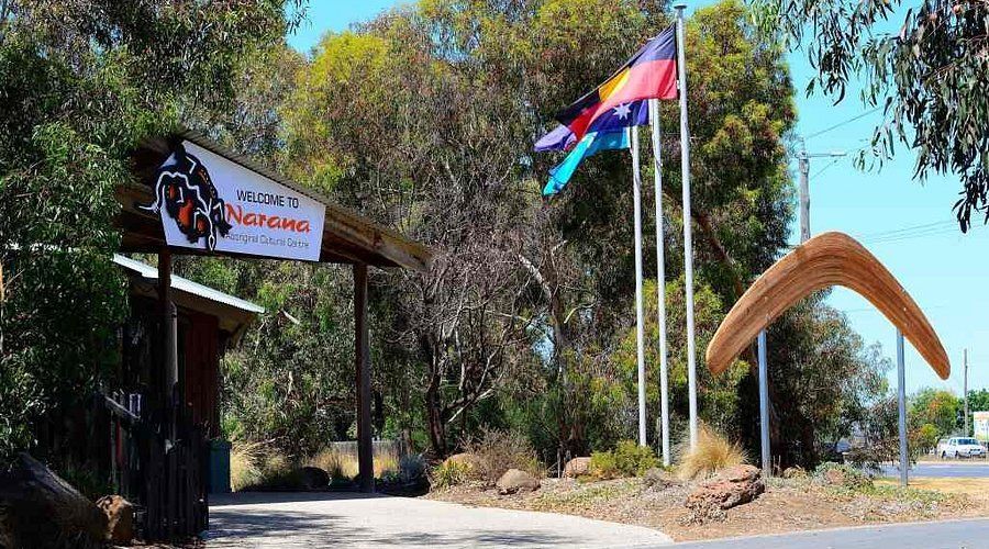 Entrance to Naracoorte, South Australia, with Aboriginal flags and a boomerang sculpture.