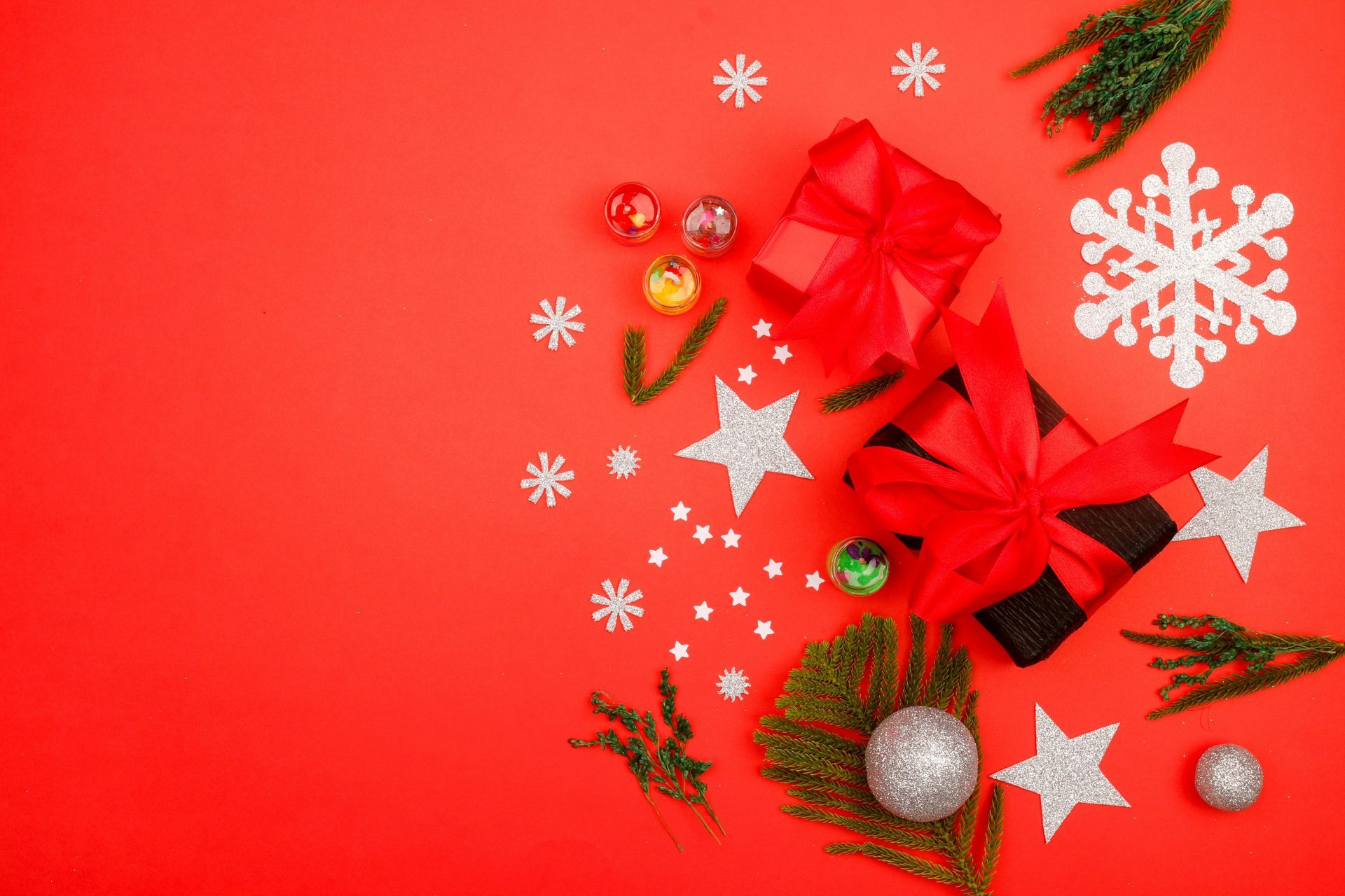 Christmas gifts with red ribbon, stars, and snowflakes on a red background.