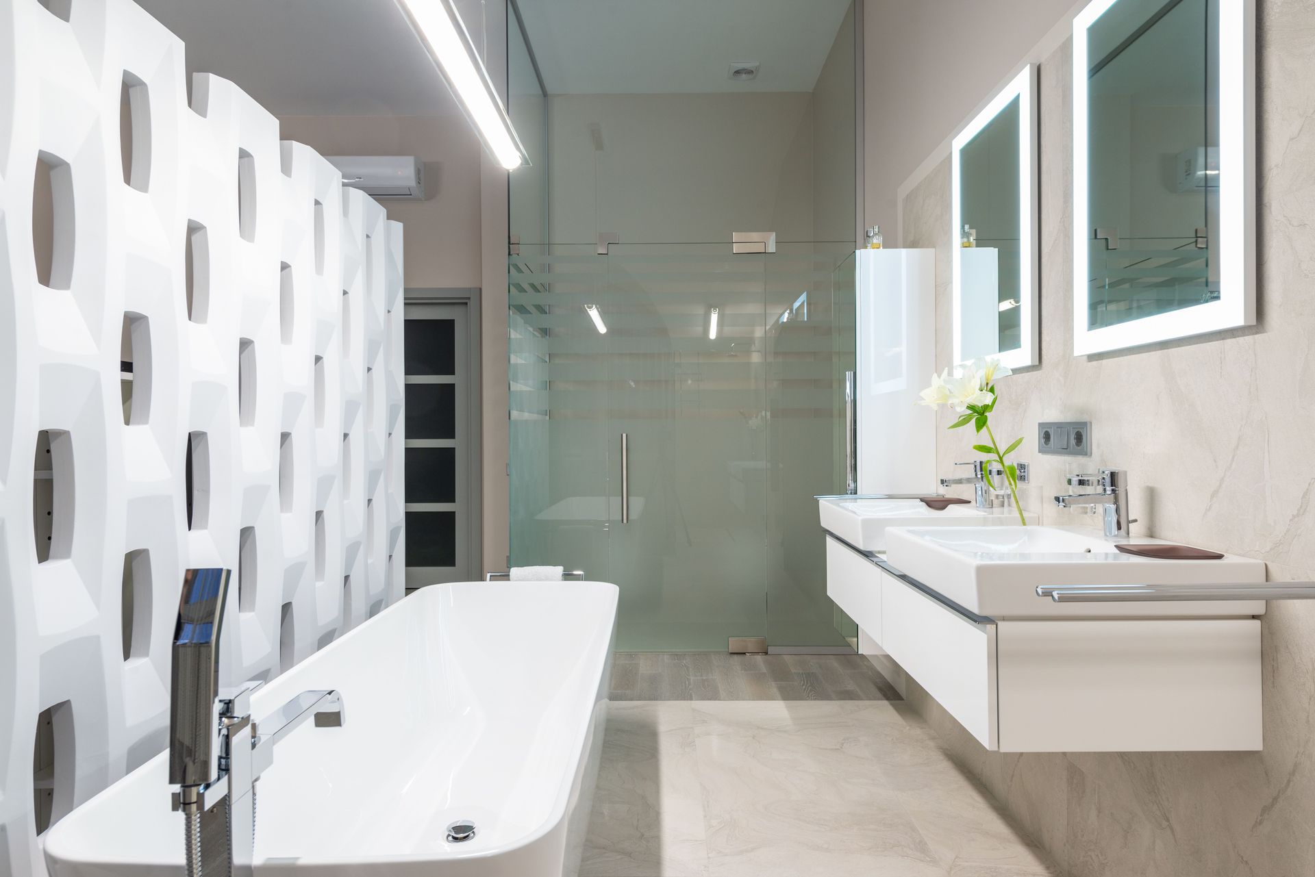 Modern white bathroom with freestanding tub, wall-mounted sink, and glass shower enclosure