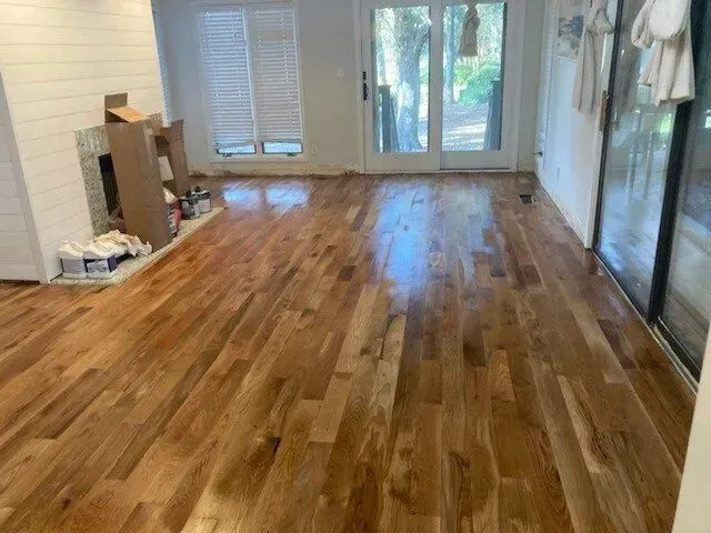A living room with hardwood floors and a fireplace.