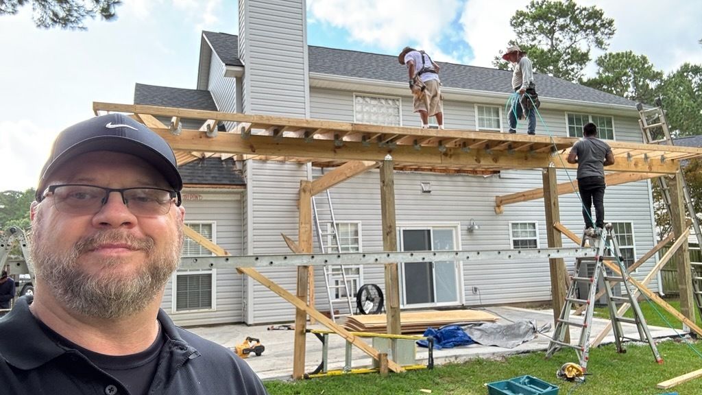 A man is standing in front of a house under construction.