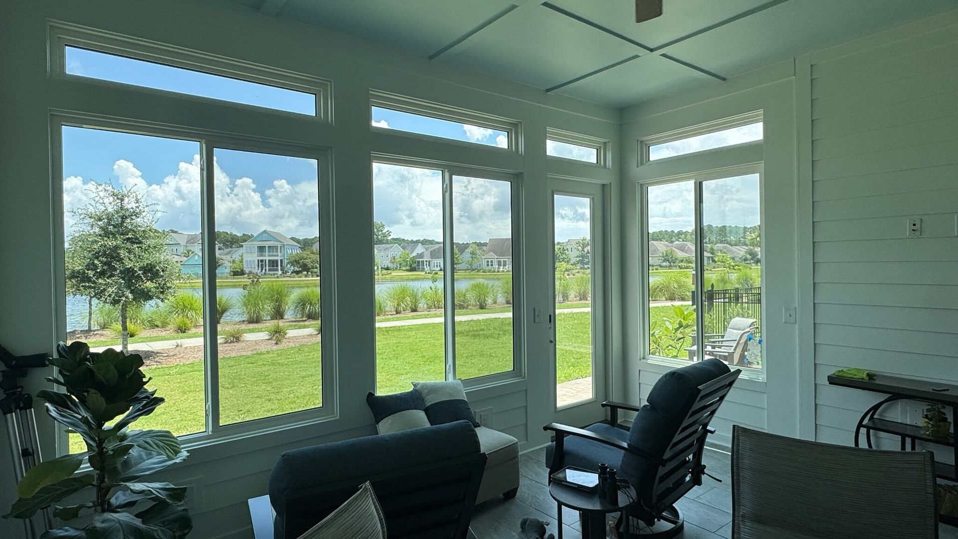 A living room with a lot of windows and a view of a lake.