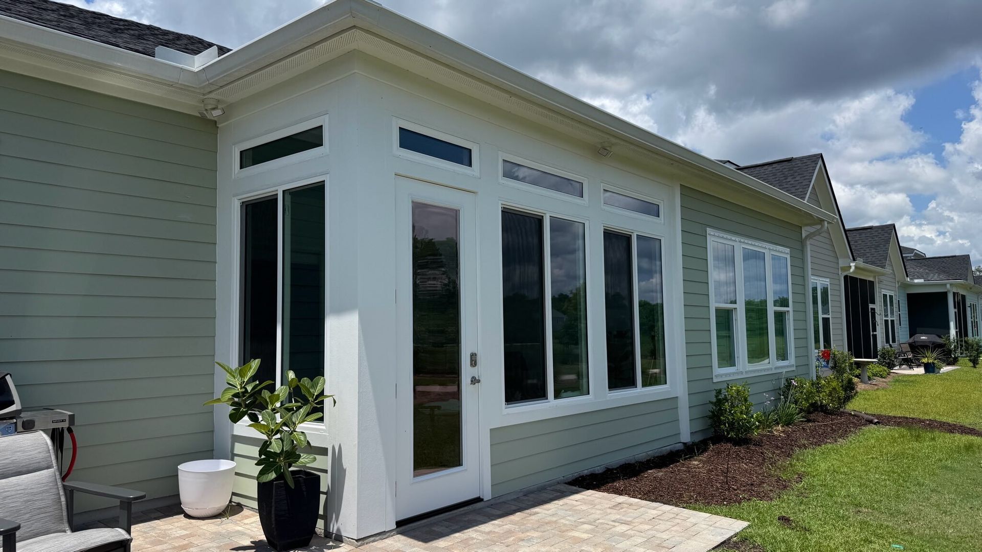 A house with a sunroom on the side of it.