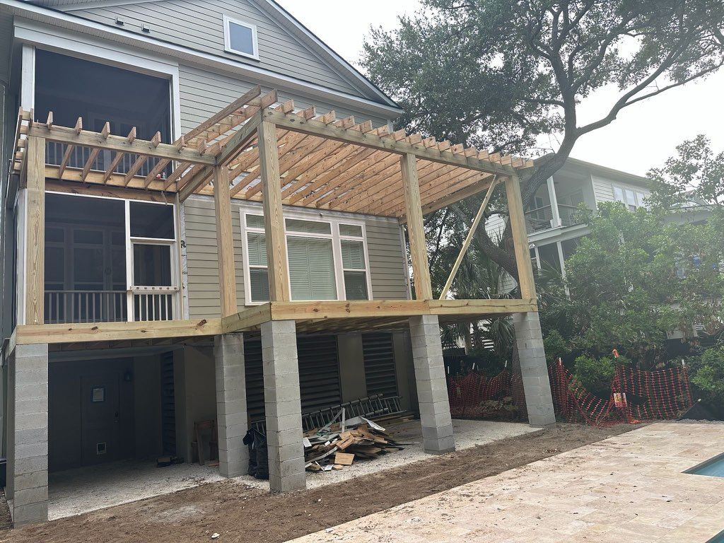 The back of a house with a wooden deck under construction.