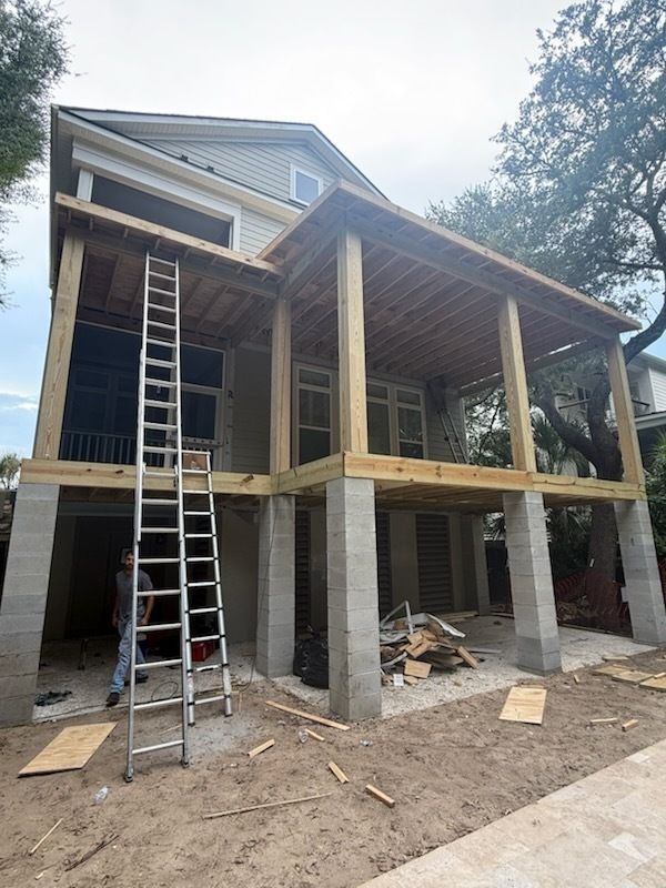A house under construction with a ladder in front of it.