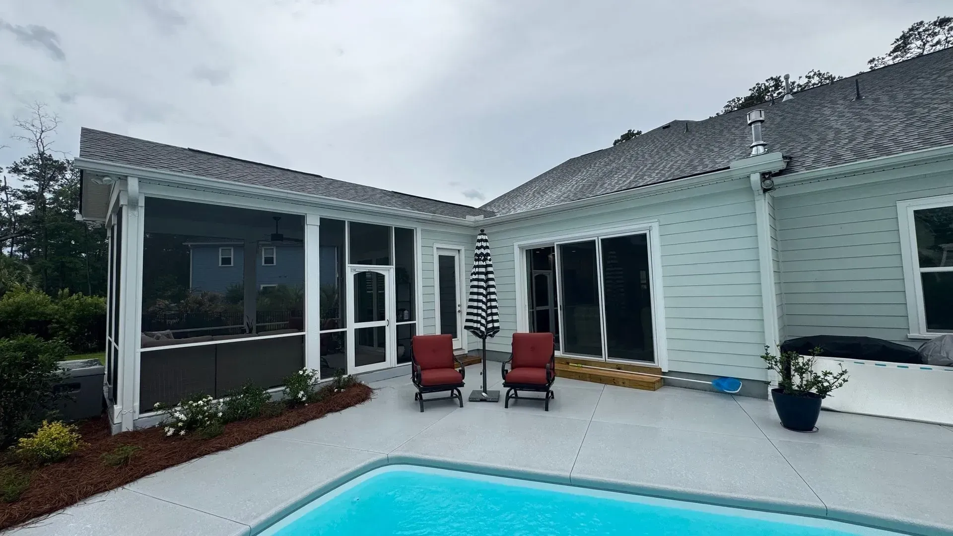 There is a swimming pool in the backyard of a house.