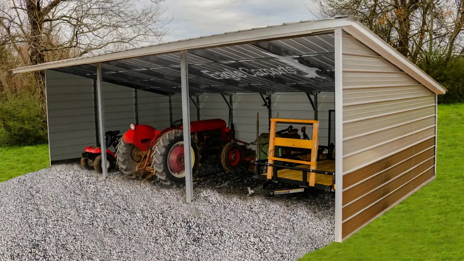 Tractor and farm equipment under a beige and brown metal shed on gravel.