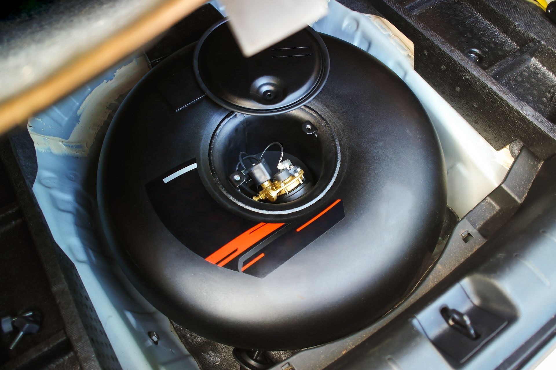 A Black, Circular LPG Tank Installed in a Car's Trunk — Warners Bay Tyre & Mechanical in Warners Bay, NSW