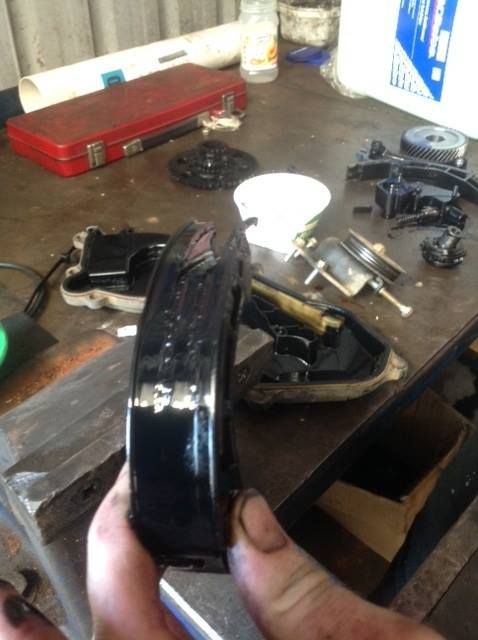 Hand Holding a Black, Curved Automotive Part Covered in Oil — Warners Bay Tyre & Mechanical in Warners Bay, NSW