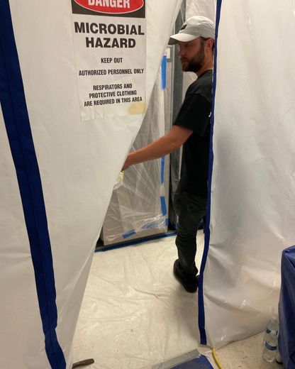 Man entering a white tent labeled 