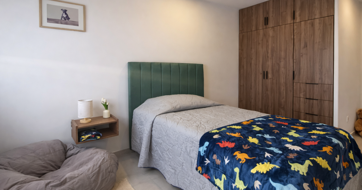Dormitorio con cama, cabecero verde, armario de madera y manta con estampado de dinosaurios para casas en Tijuana