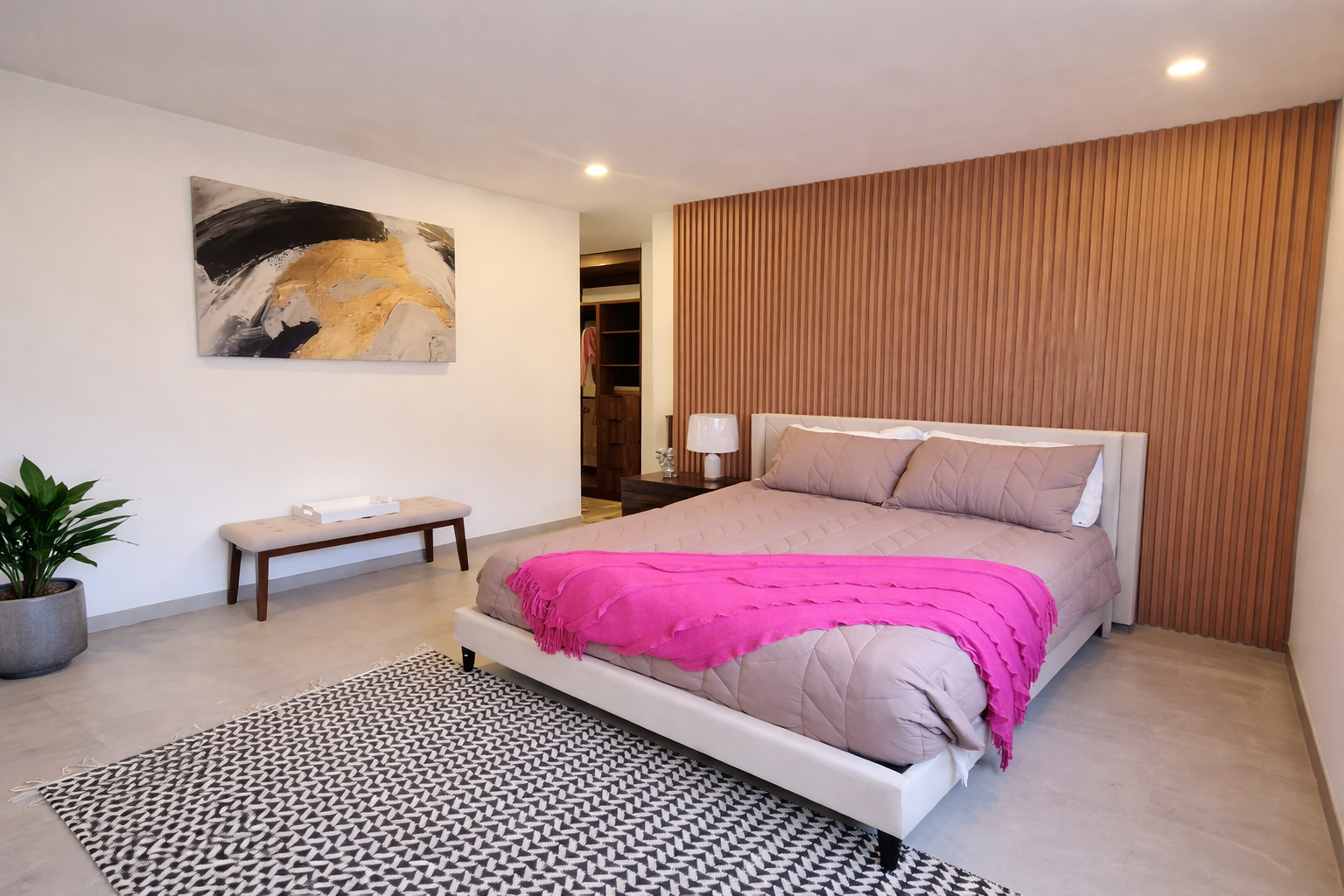 Dormitorio con cama, banco, alfombra, obras de arte y una pared con detalles de paneles para casas en Tijuana