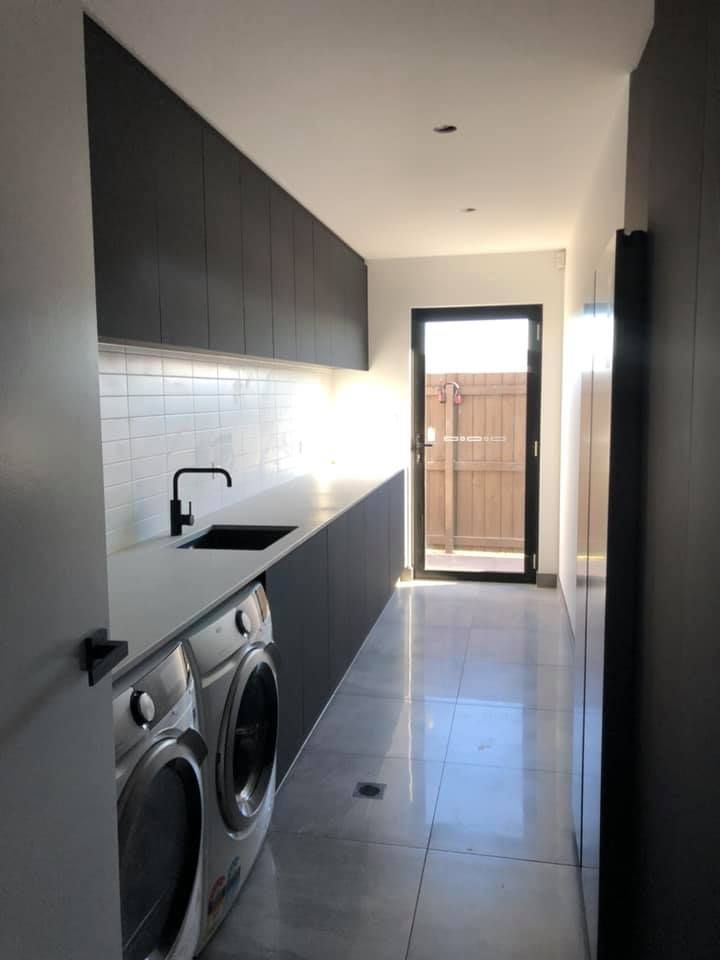 A laundry room with a washer and dryer and a sink