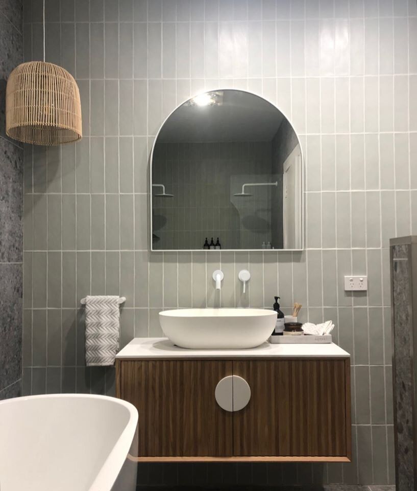 A bathroom with a sink , mirror and bathtub.