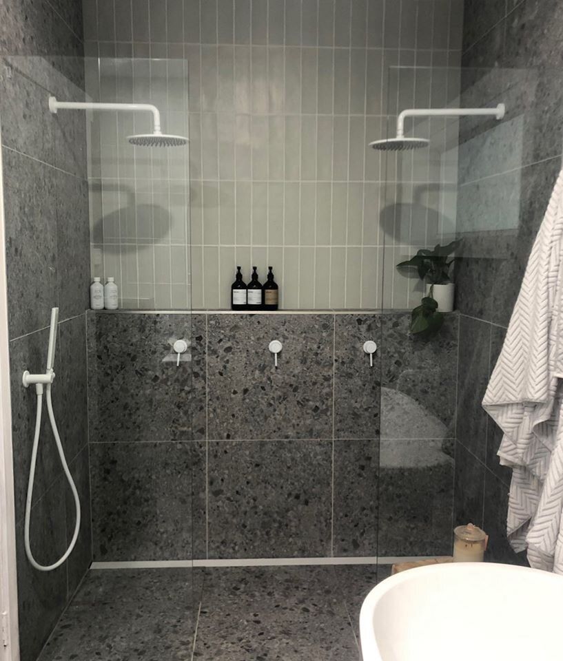 A bathroom with a walk in shower and a sink.