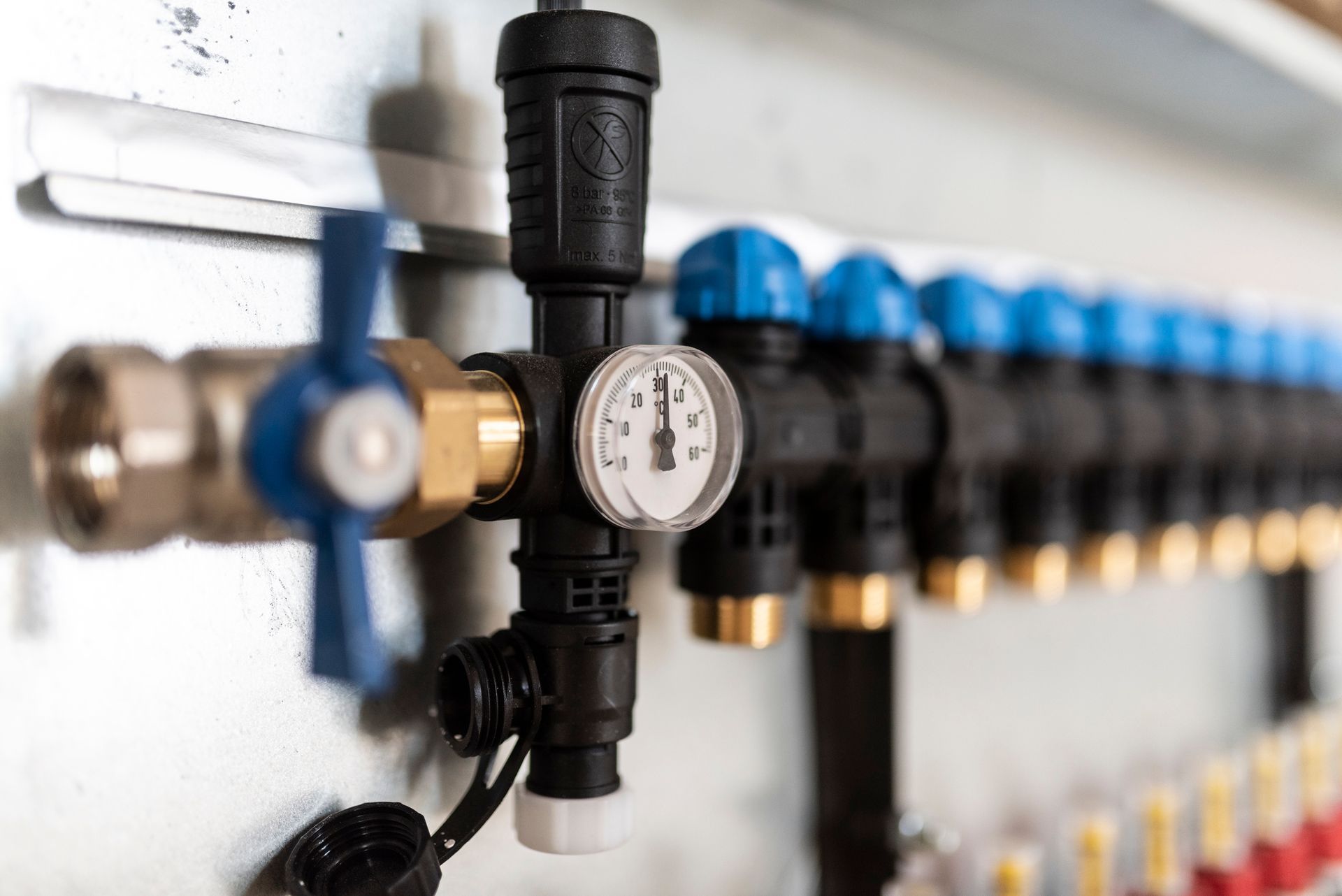 A close up of a hose with a gauge attached to it.