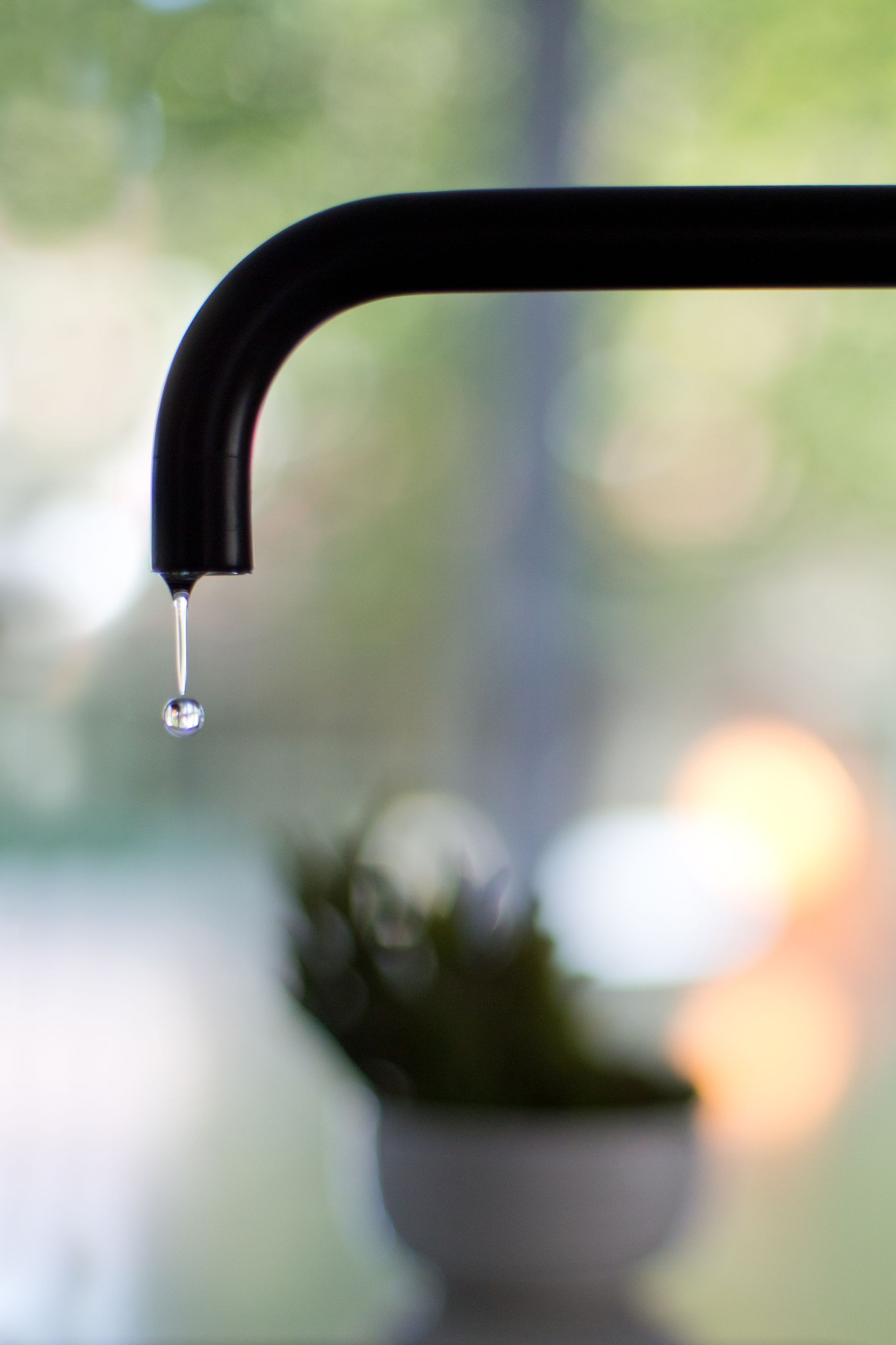 A man is fixing a boiler with a wrench and a towel.