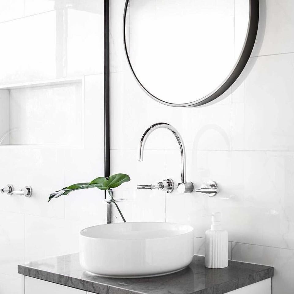 A bathroom with a sink , mirror and soap dispenser.