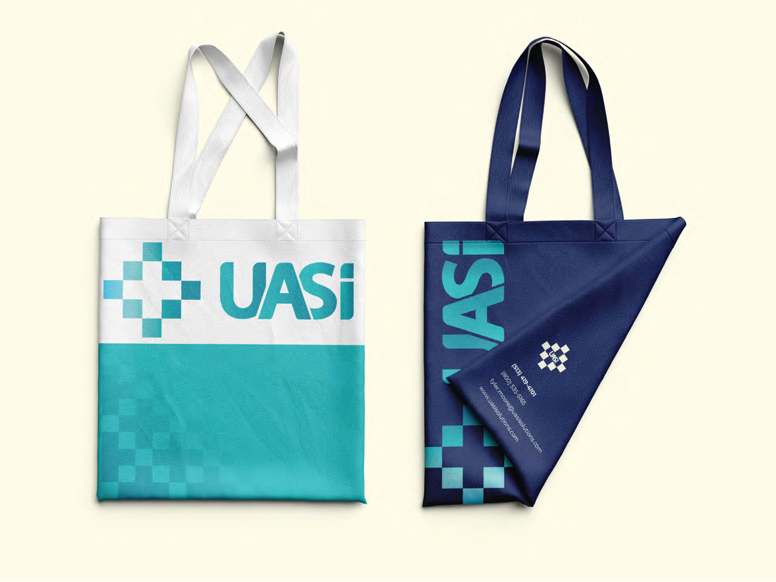Two tote bags, one white and turquoise, the other navy, with the UASI logo.