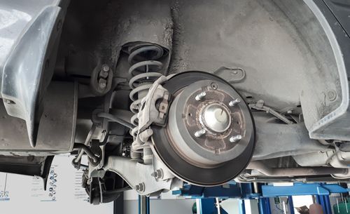Close-up of a car’s disk brake inside a compartment, while being serviced in a repair shop. — Geelong VIC — Auto Express Service Centre & Mobile Mechanics