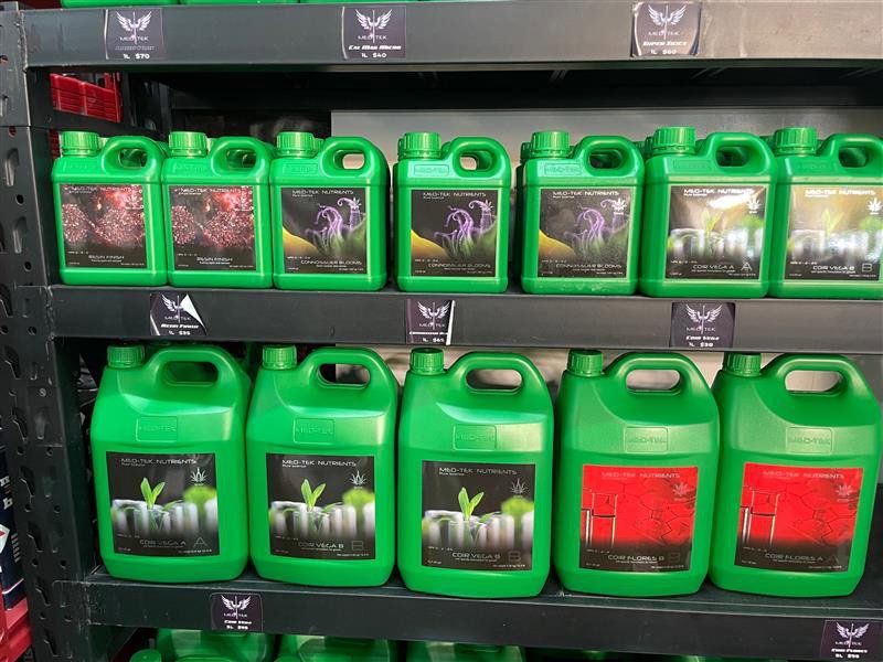 A Shelf Filled With Green Bottles of Fertilizer in a Store — Cairns Hydroponics In Bungalow, QLD