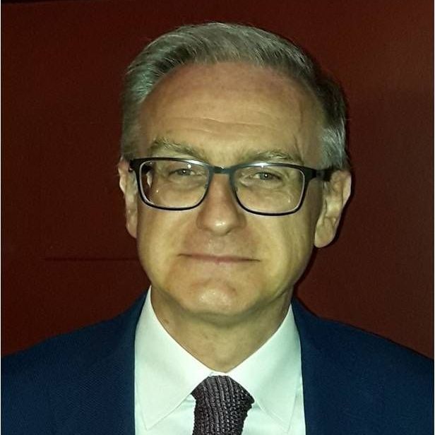 Un uomo con gli occhiali, giacca e cravatta