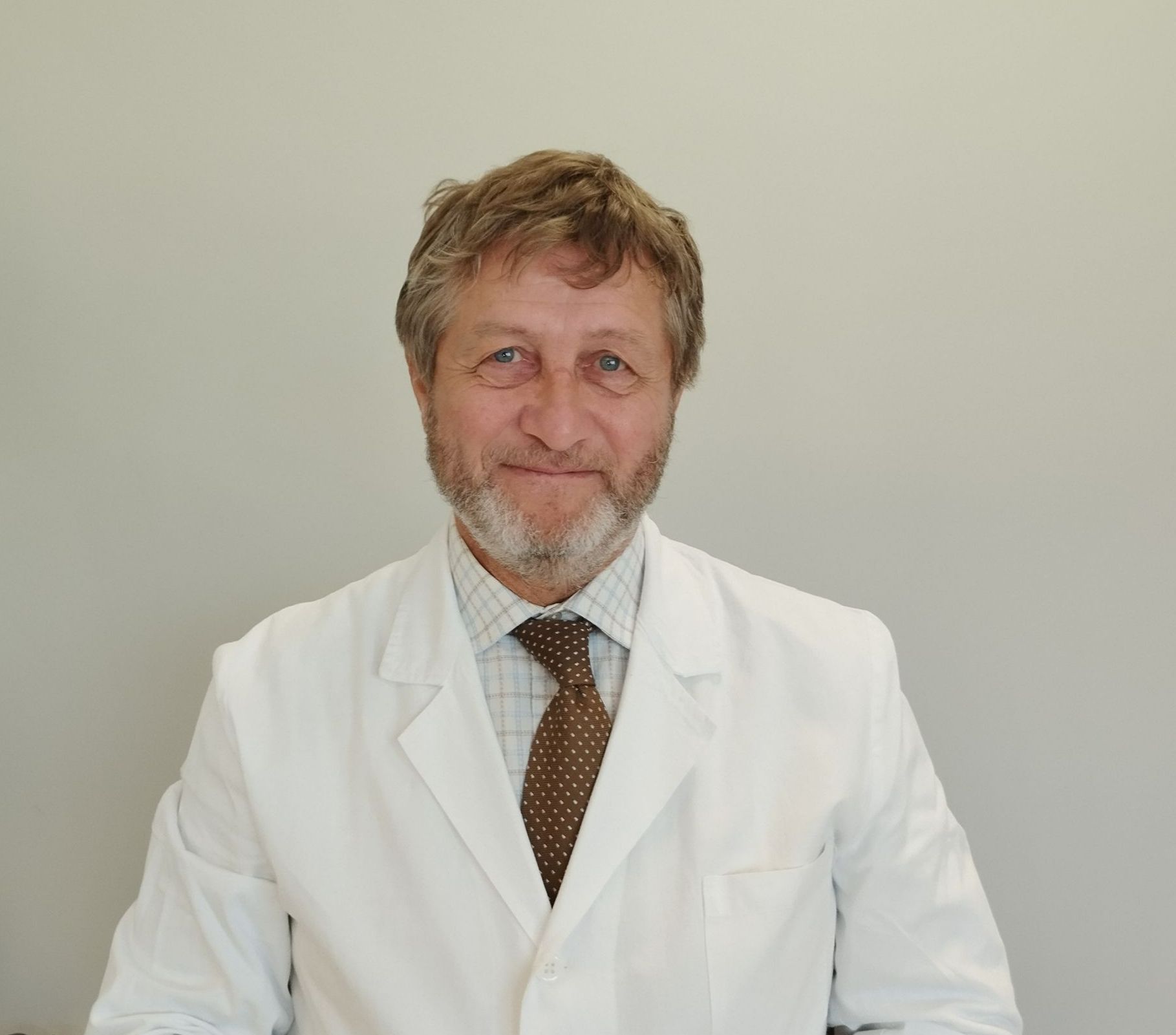 Un uomo con la barba che indossa un camice bianco e una cravatta