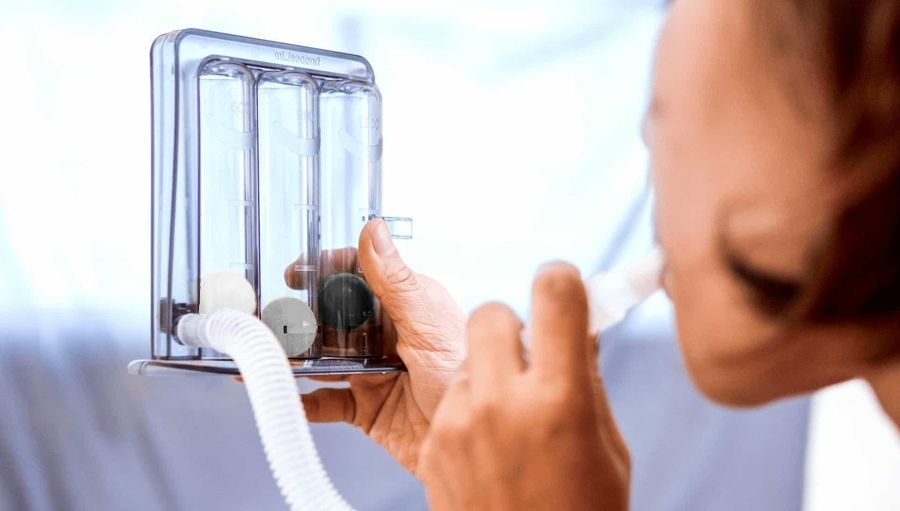 Una persona che indossa guanti blu tiene in mano una penna e indica una radiografia.