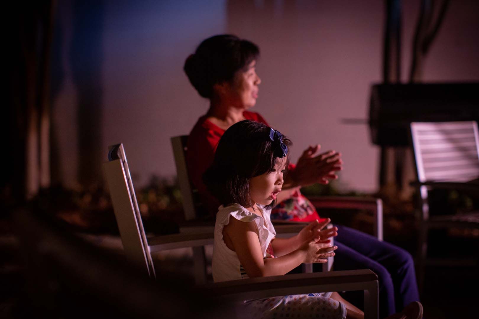 A woman and a little girl are sitting in rocking chairs.