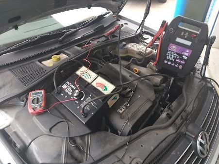 The Hood Of A Car Is Open And A Battery Is Being Charged — Albion Park Auto Electrical & Mechanical In  Albion Park Rail, NSW
