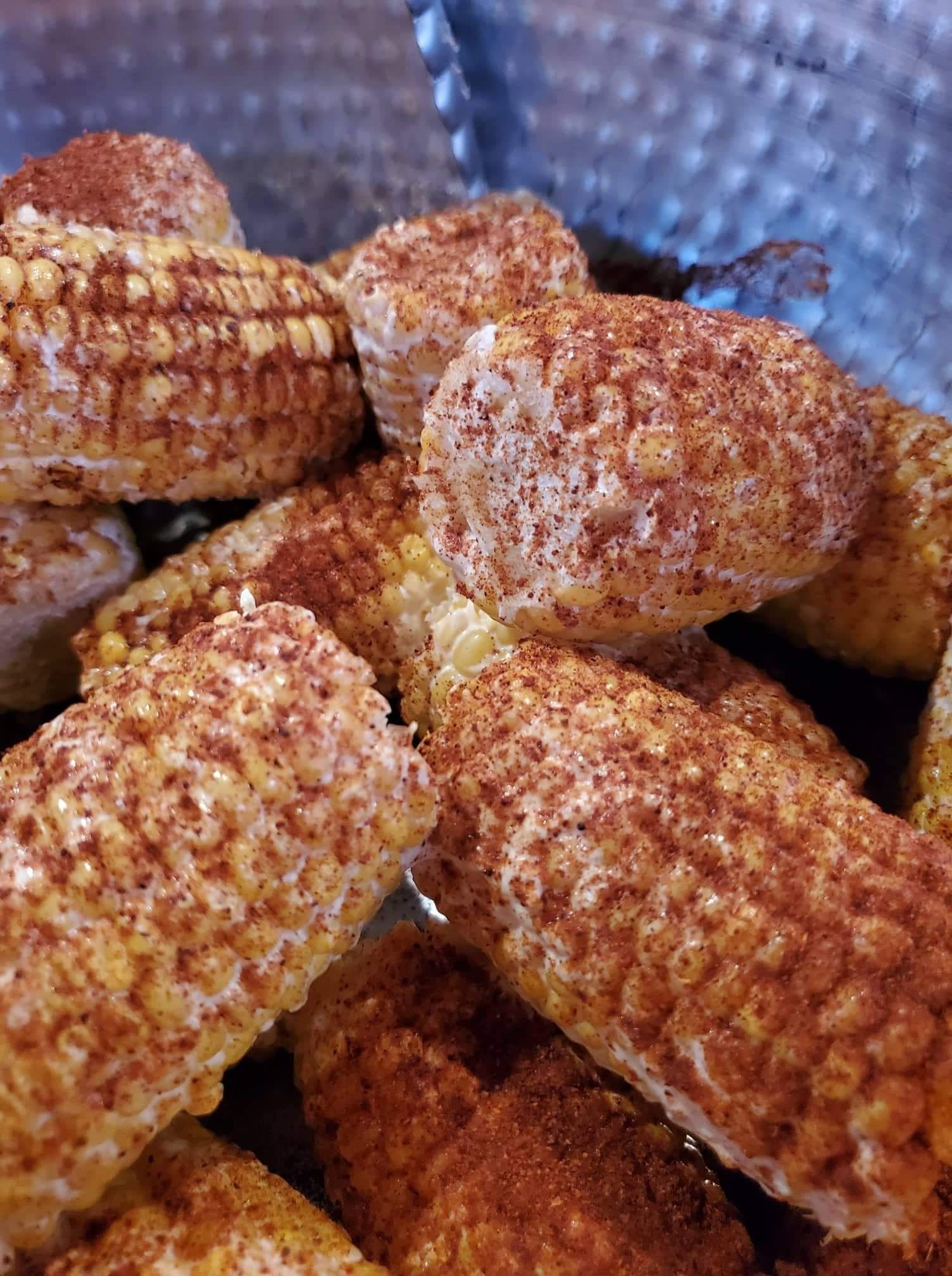 A close up of a pile of corn on the cob covered in cinnamon.
