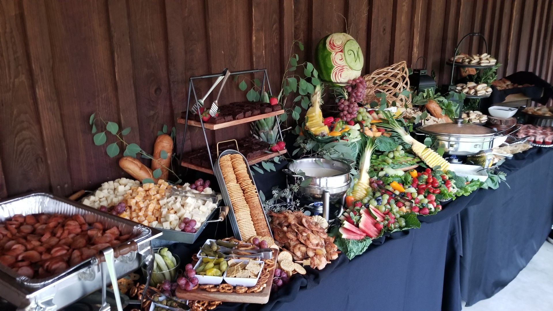 A buffet table filled with lots of food and vegetables.