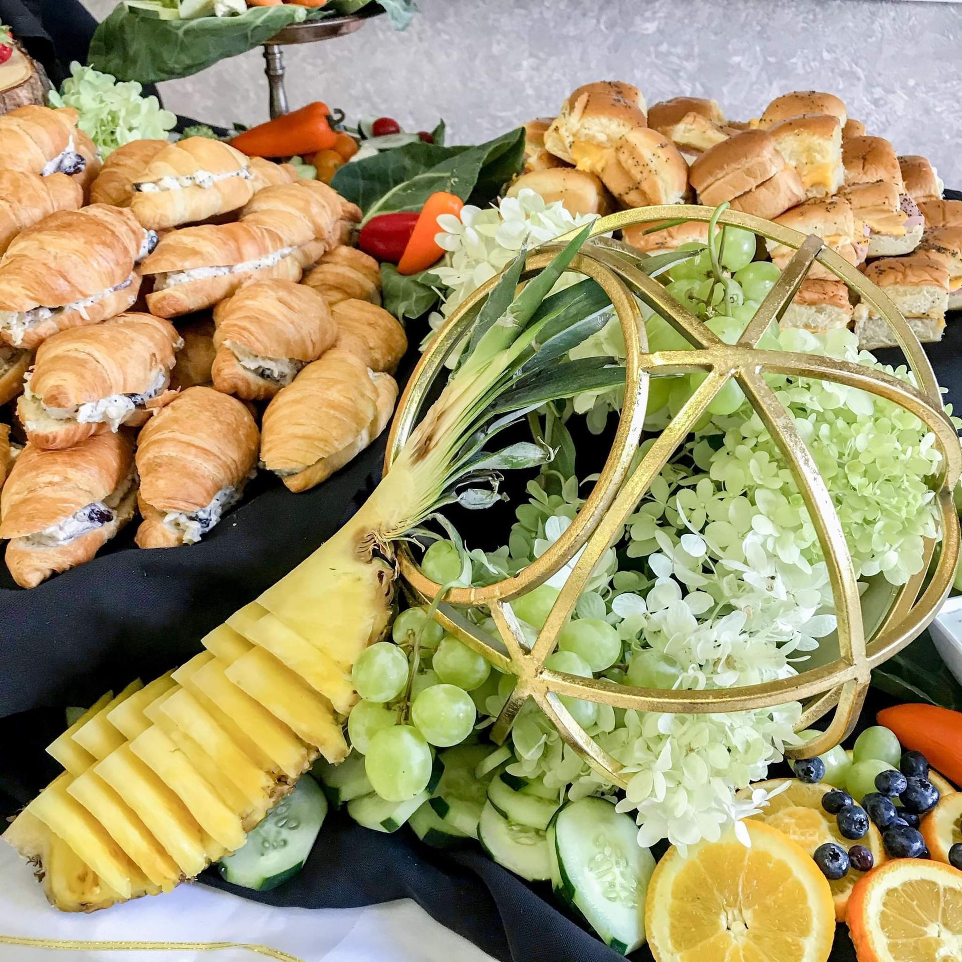 A buffet table with fruits and croissants on it