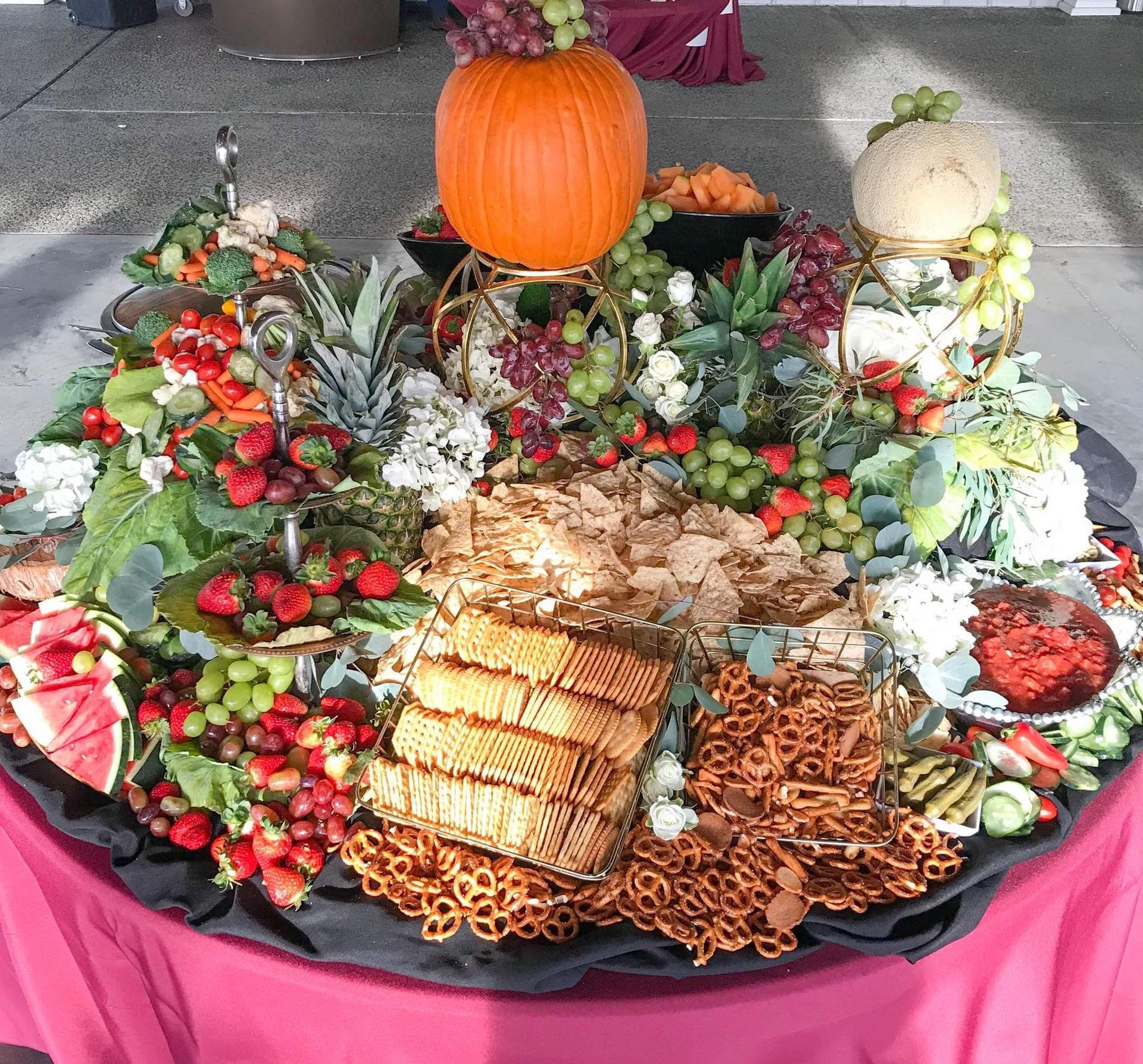 A display of fruits and vegetables with a pumpkin on top