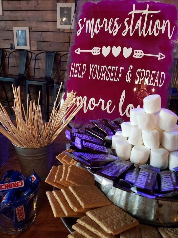 A s'mores station with a sign that says `` help yourself and spread more love ''