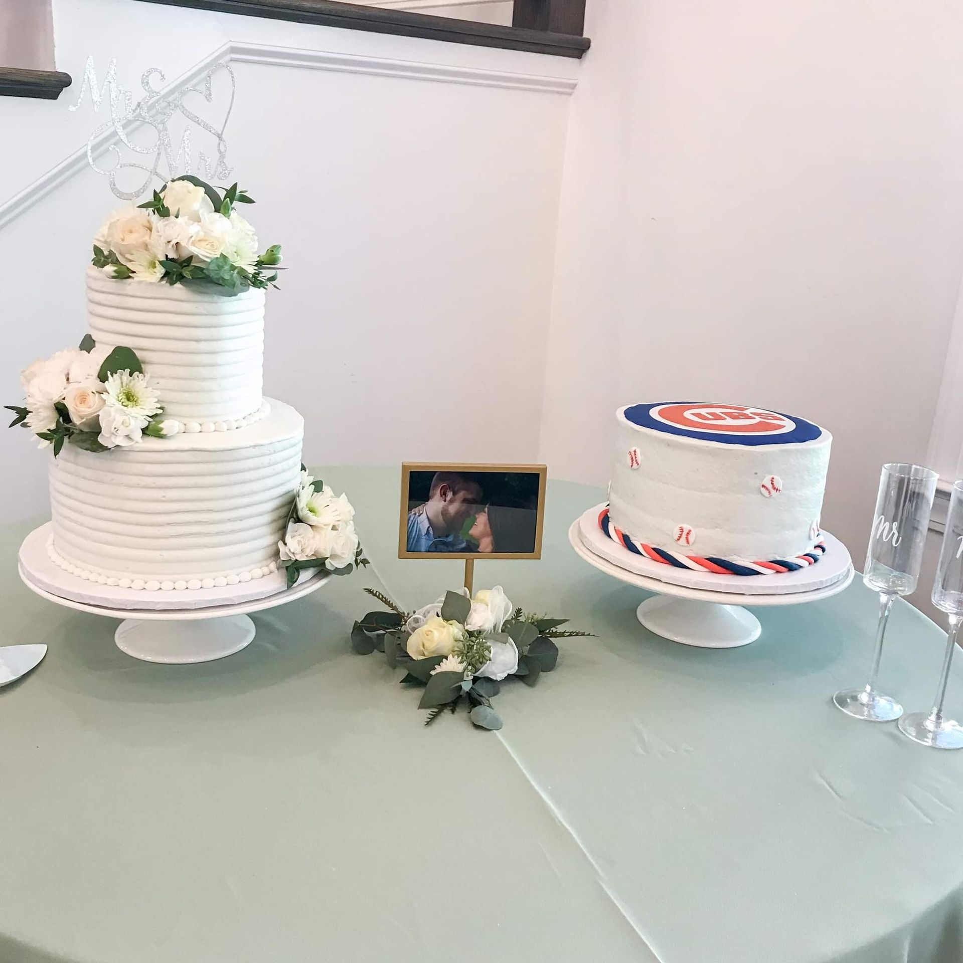 Two wedding cakes are sitting on a table next to each other.