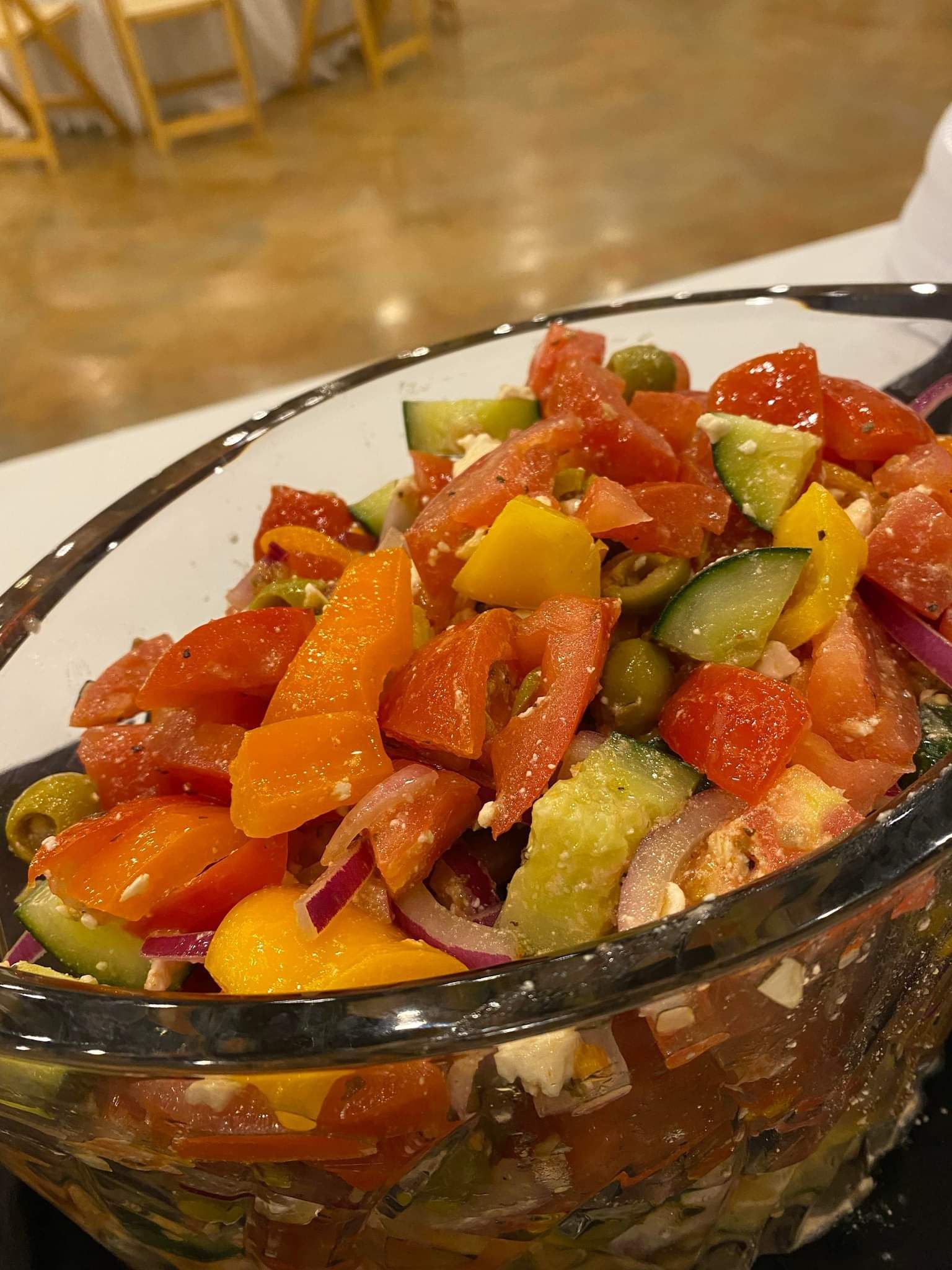 A close up of a salad in a glass bowl on a table.