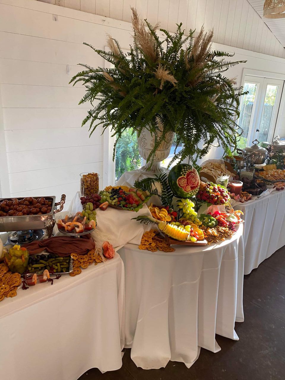 A buffet table with a vase of flowers on top of it.