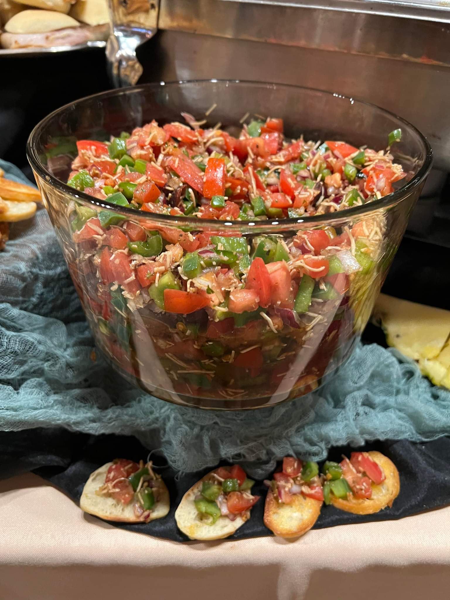 A bowl of salsa is sitting on a table next to crackers.