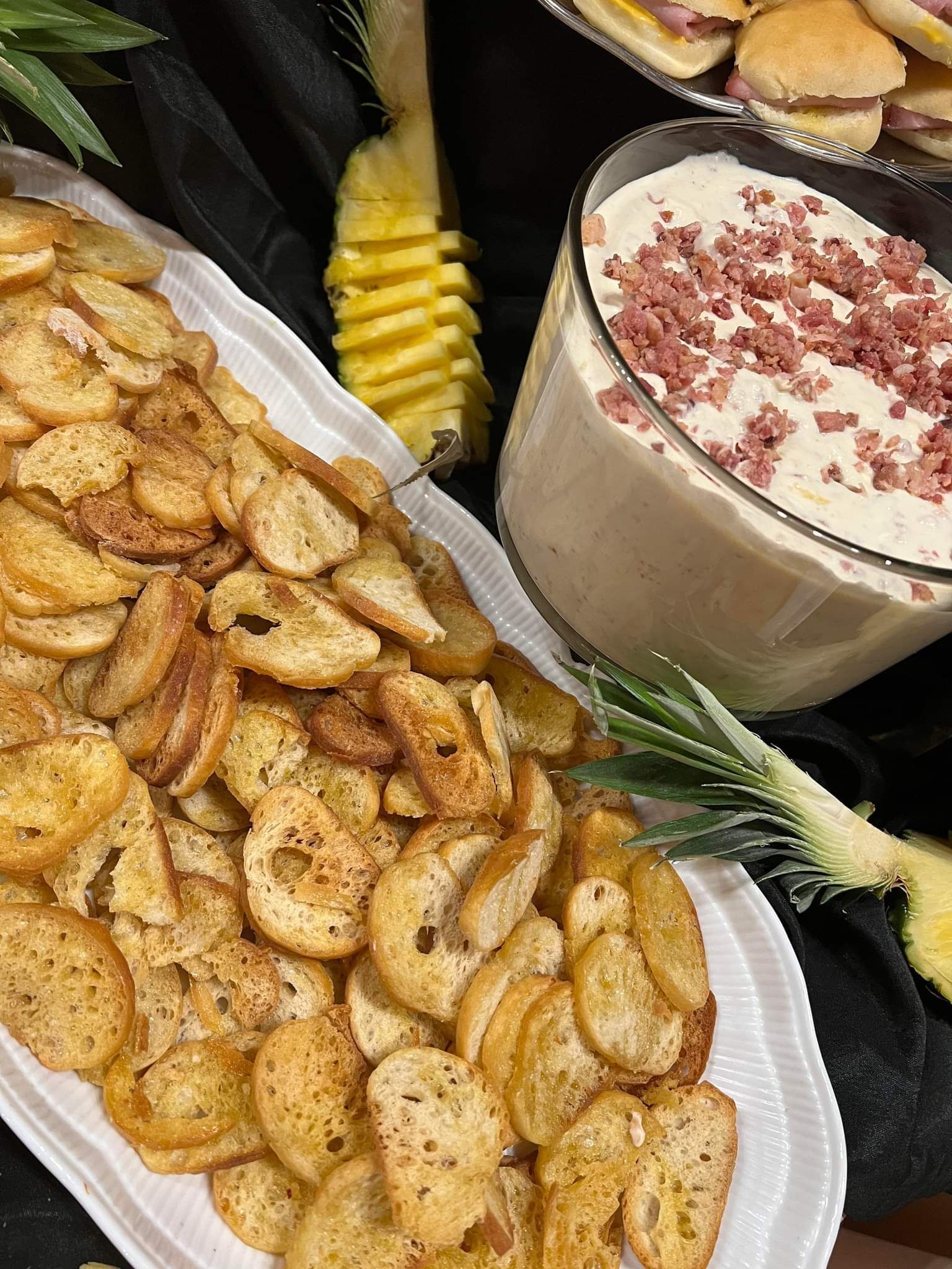 A plate of crackers and a bowl of dip on a table.