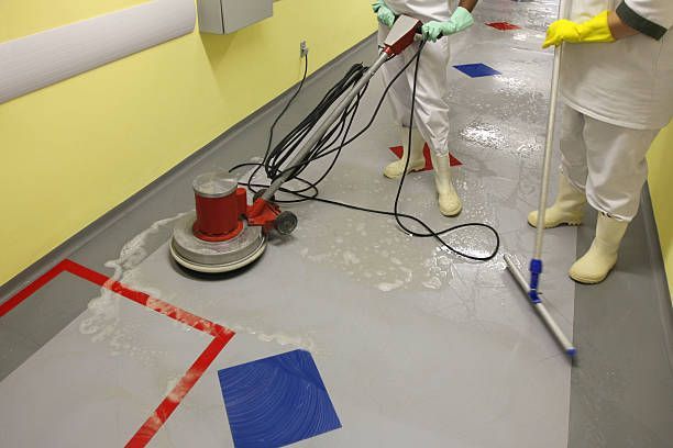 A person is cleaning a floor with a vacuum cleaner