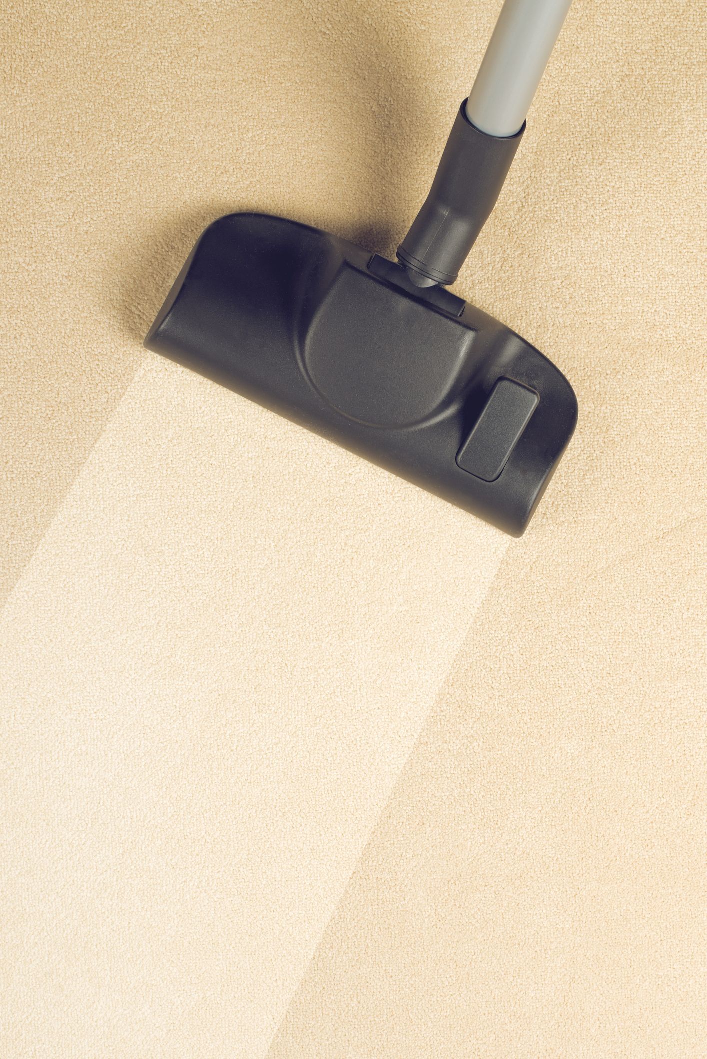 A close up of a vacuum cleaner cleaning a carpet