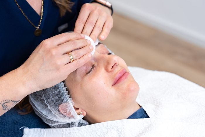 eine frau hält eine pipette und eine flasche in der hand