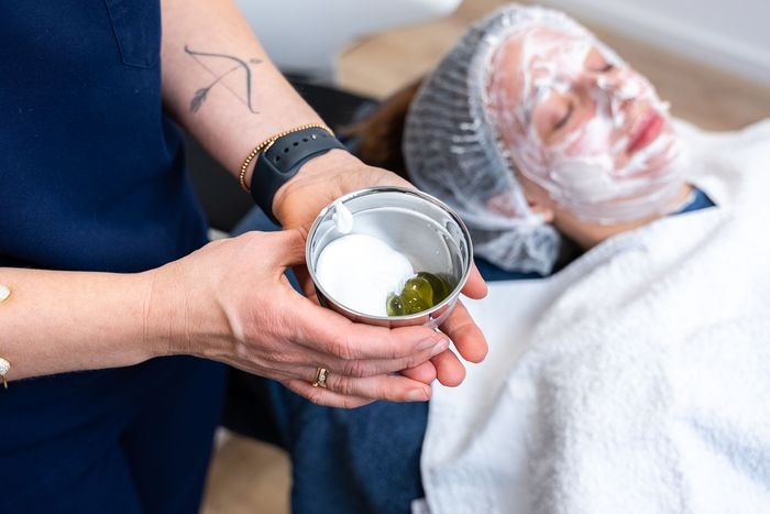 eine frau hält eine pipette und eine flasche in der hand