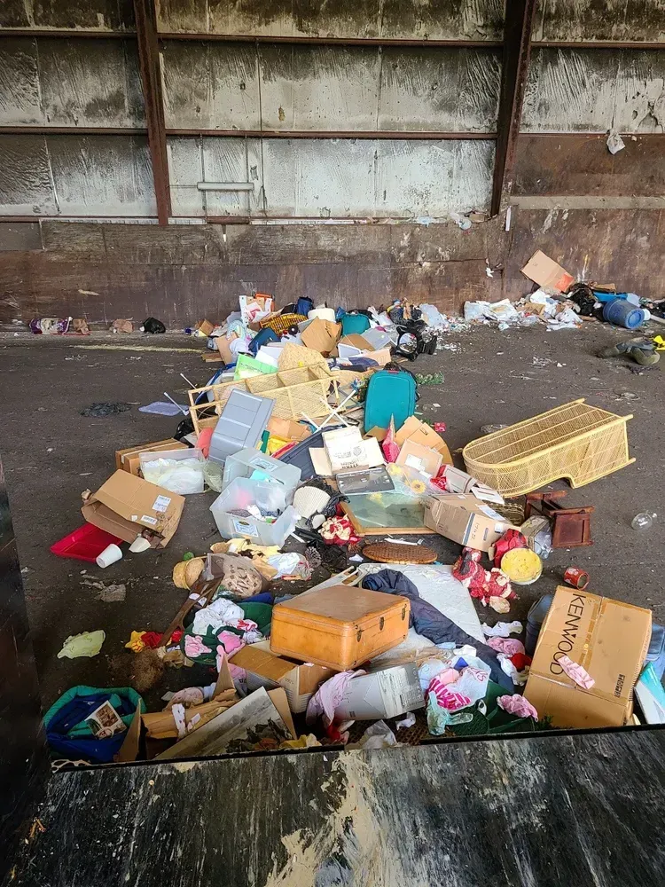 A pile of trash is sitting on the ground in a room.