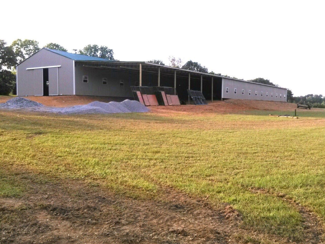 A large building is sitting in the middle of a grassy field.